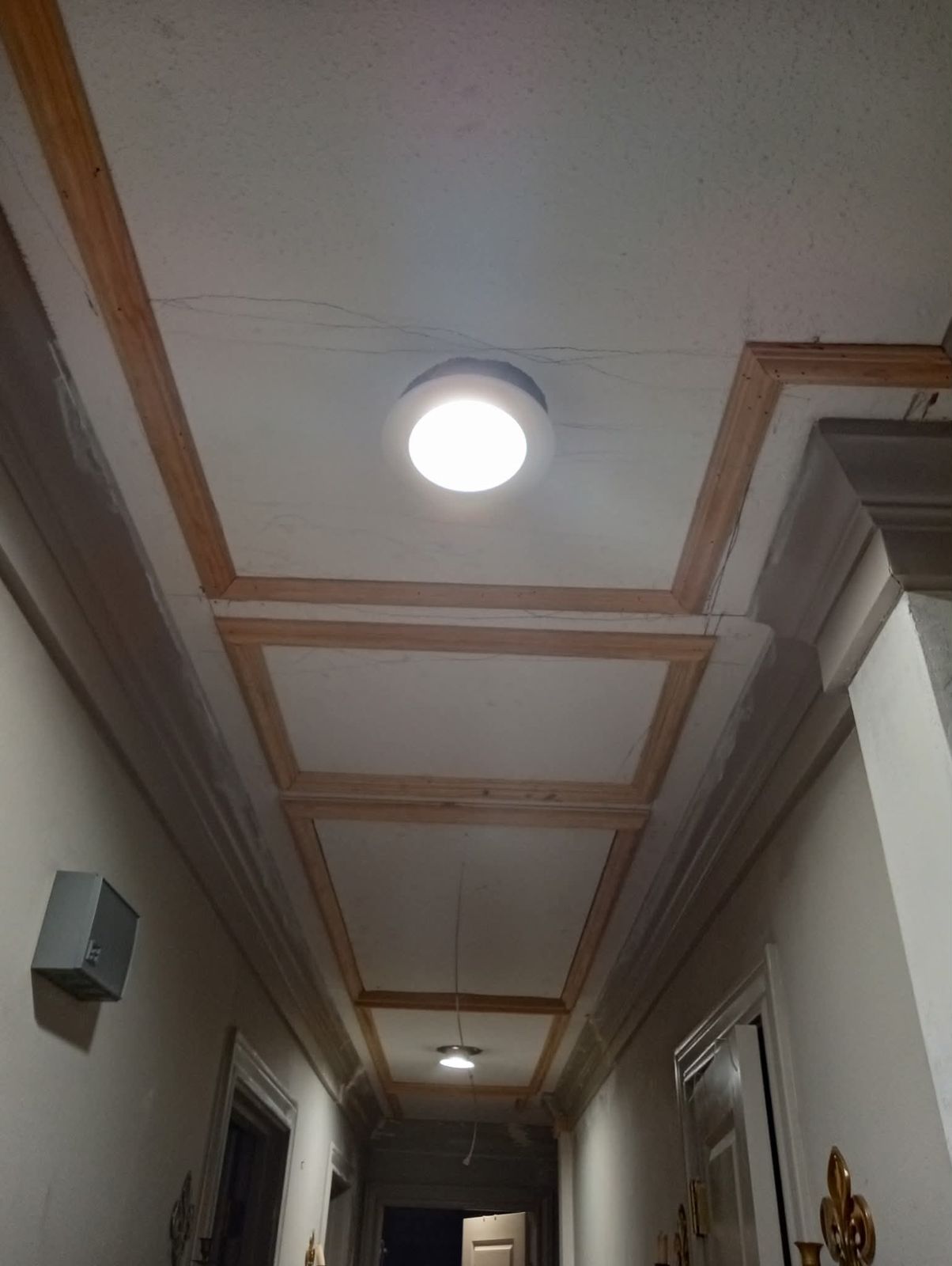 Trim molding being installed on a hallway ceiling