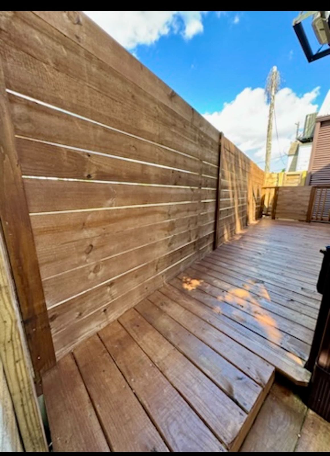 Stained horizontal board fence beside a deck